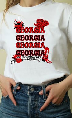 "Cute  Georgia Bulldog Shirt  Gildan Soft Style Shirts are used.  4.5 oz., 100% preshrunk ring spun cotton Antique colors & Sport Grey: 90% ring spun cotton, 10% polyester Graphite Heather is 50% ring spun cotton, 50% polyester Heather colors & Blackberry: 65% polyester, 35% ring spun cotton The color \"Natural\" is made with unprocessed, unbleached cotton, which results in small black flecks and plant fibers throughout the fabric. When unavailable 100% Cotton shirts will be used. **Sizing: Unisex shirt so lose fit. Shirts run true to size. See sizing chart in pictures. **Recommend Care Instructions: Machine Wash Tumble Dry. **Processing time: Is usually 1-3 Business Days. During busier times of the year it exceed. Please see shipping and delivery times listed by Etsy below. Check out Joy Western Disco, Bulldog Football, Georgia Bulldogs Shirt, Jesus Design, Football Graphic Tee, Georgia Football, Bulldogs Football, Groovy Font, Bulldog Shirt