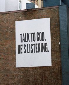 a sign on the side of a building that says talk to god he's listening