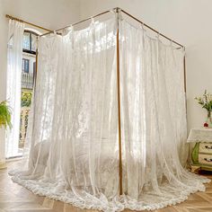 a room with a bed and white curtains