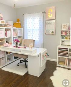 a room filled with lots of white furniture and shelves next to a window covered in pink flowers