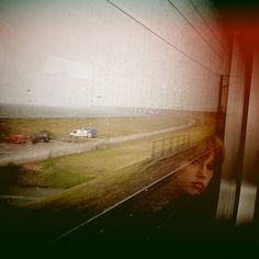 a woman looking out the window of a train