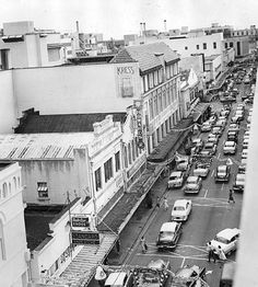 an old black and white photo of traffic on a city street