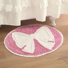 a pink and white rug with a bow on it