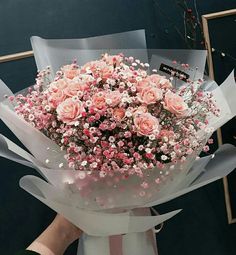 a person holding a bouquet of pink flowers