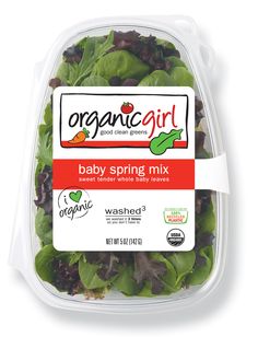 organic baby spring mix with spinach and carrots in a plastic container on a white background