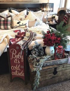 a bed room with a wooden box filled with christmas decorations and pillows on top of it