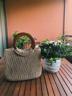 a basket sitting on top of a wooden table next to a potted plant