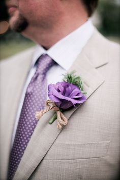 a man wearing a suit and tie with a boutonniere on his lapel