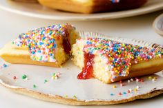 two pieces of cake with sprinkles on a plate next to another one