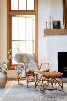 a rocking chair in front of a fireplace with a fur rug on the floor next to it