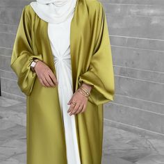 This Emirati Puff Sleeve Satin Open Abaya is the perfect statement piece for any outfit in 6 beautiful pastel colors. Wear with or without the matching belt for a stunning emarati look. Has pockets on the sides. Can be worn with one of our inner dresses, a matching set, or jeans on the go. Modest Long Dresses, Blue Abaya, Moda Kimono, Party Long Dress, Abaya Kimono, Abaya Style, Open Abaya, Islamic Dress, Mode Abaya