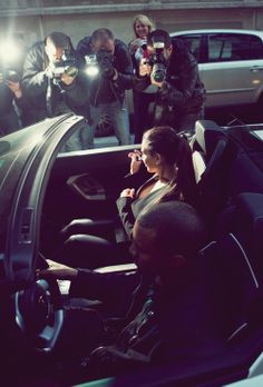 a group of people sitting in the back of a car with cameras on their laps