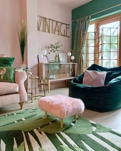 a living room with green and pink furniture, rugs and pillows on the floor