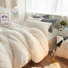 a bed with white comforters and pillows in a room