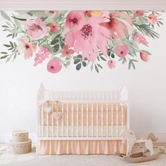 a baby's room with a crib and flowers painted on the wall