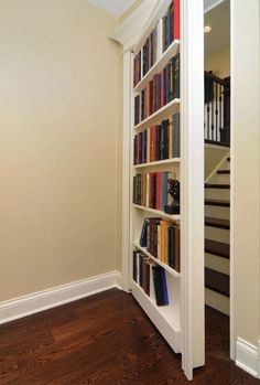 a bookshelf filled with lots of books next to a stair case