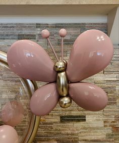 a pink and gold butterfly sculpture in the shape of a ballon - like flower