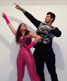 a man and woman dressed up in costume posing for a photo with their arms outstretched