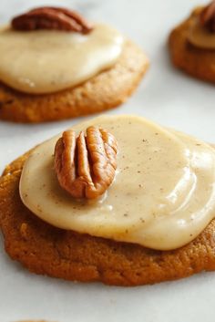 several cookies with frosting and pecans on top