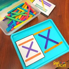 two trays filled with colored pencils next to each other on top of a wooden table