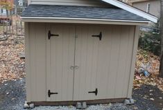 an outdoor storage shed with two doors on the side