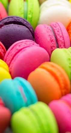 many different colored macaroons are in a pile on the table and there is no image here to provide a caption for