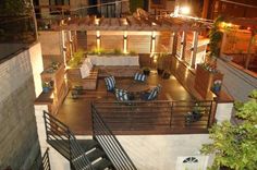 an aerial view of a patio and deck area at night with lights on the roof