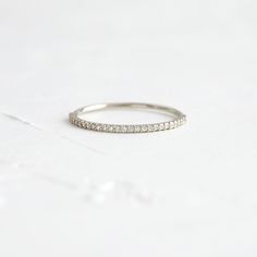 a white gold wedding band with small diamonds on the side, set in 18k white gold