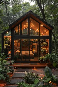 a small cabin in the middle of some trees with lights on it's windows