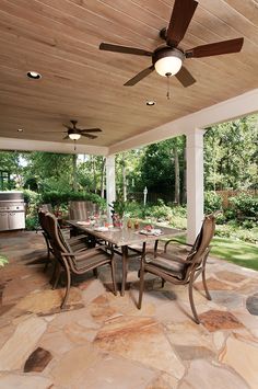 an outdoor dining area with table, chairs and ceiling fan