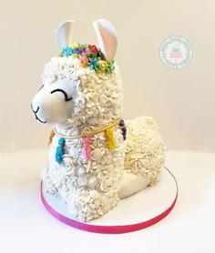 a cake shaped like a llama with flowers on it's head and ears