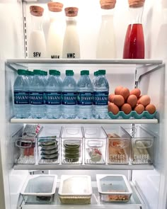 an open refrigerator with milk, eggs and other food items in the freezer compartment