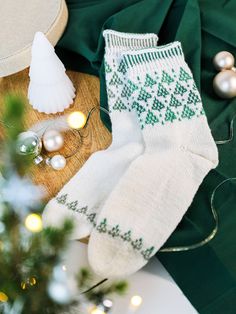 a pair of white socks sitting on top of a table next to a christmas tree