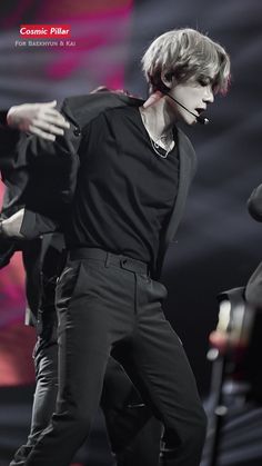 a male in a black shirt and pants on stage