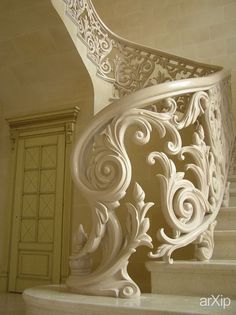 an ornate white staircase with handrails in a house or office building, looking down at the stairs