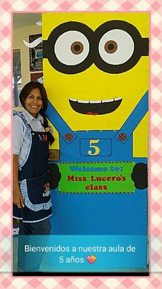 a girl standing in front of a sign with a minion on it