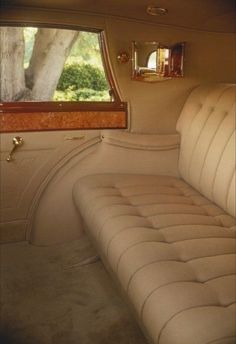 the interior of an old car with beige upholstered seats and wood trimming