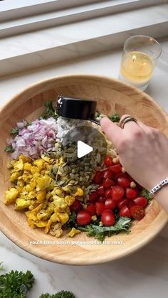 a wooden bowl filled with different types of food on top of a white countertop