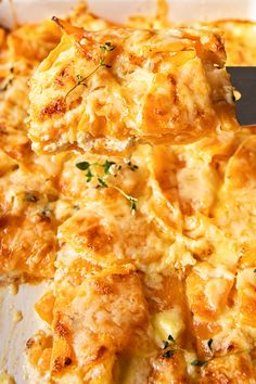 a close up of a casserole in a pan with a spatula on it