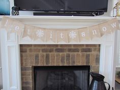 a fireplace with a television above it and a snowflake banner on the mantle