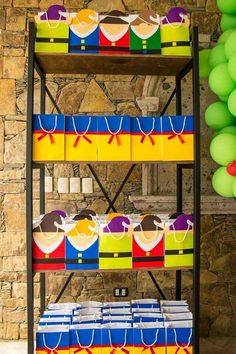 three tiered shelf with colorful boxes on it next to green balloons and streamers