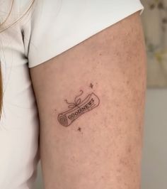 a woman with a tattoo on her thigh that says godmots and is holding a roll of toilet paper