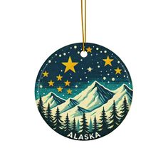 a round ornament with the words alaska written on it and stars in the sky