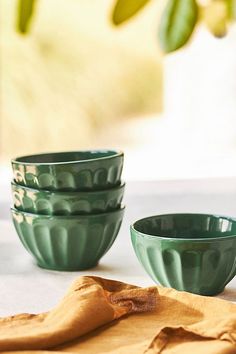 three green bowls sitting on top of a table