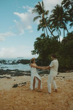 a man and woman dancing on the beach with palm trees in the backgroud