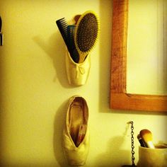 two pairs of shoes are hanging on the wall next to a hairbrush and comb