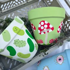 three potted plants sitting next to each other on top of a metal shelf in front of a basket