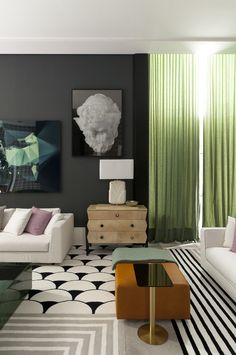 a living room filled with white furniture and green curtains