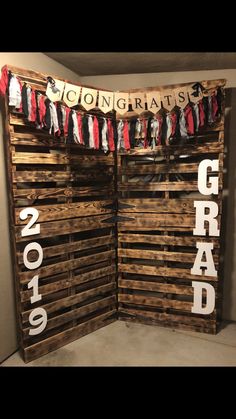 the graduation sign is made out of wooden pallets and hung up on a wall