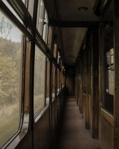 the inside of a train car with windows on both sides and trees in the background